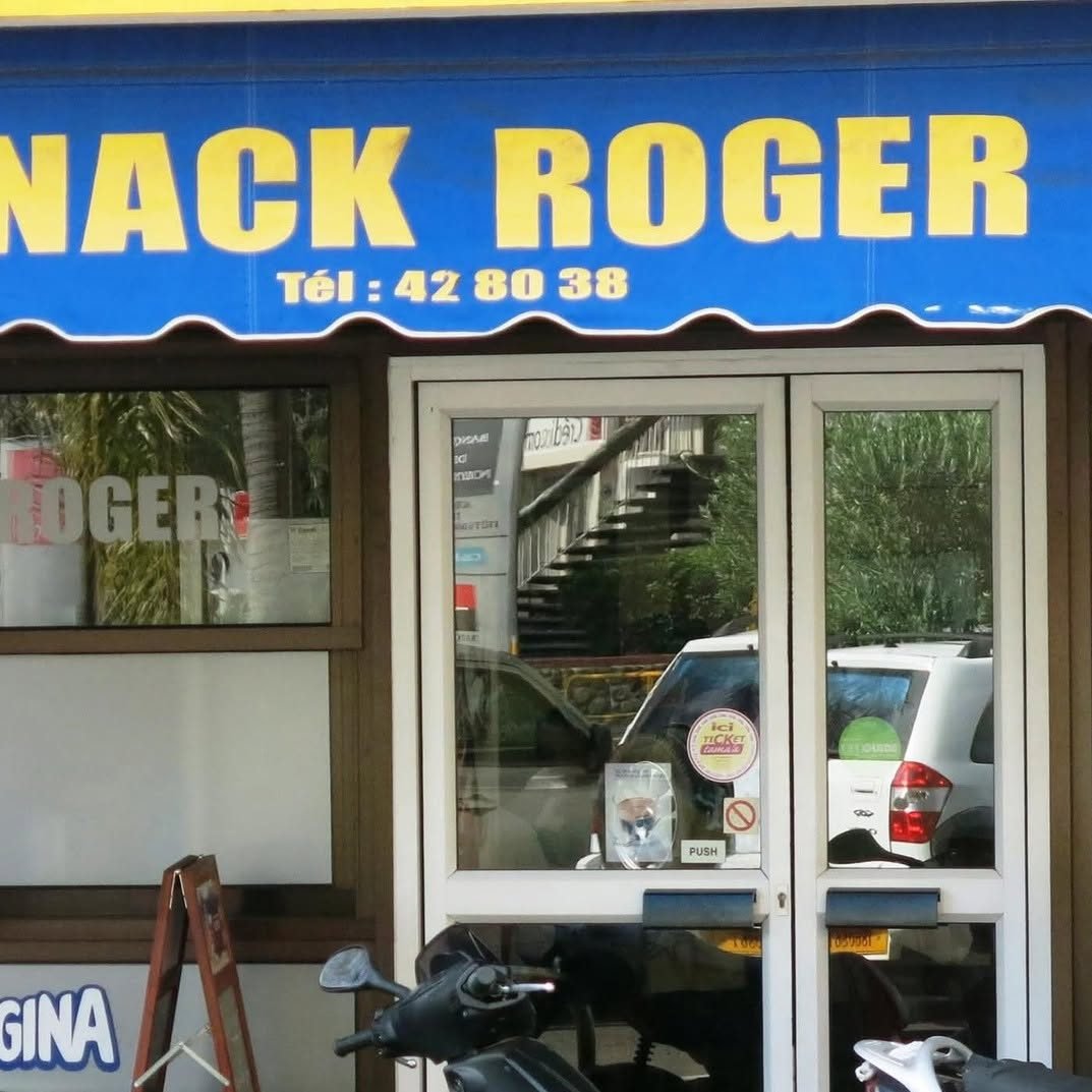 Enseigne bleue et jaune du Snack Roger au-dessus de la porte